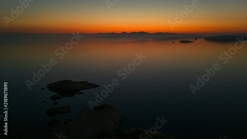 Quiet early pre dawn sunrise with colorful sky over Aegean Sea at Mandrakia village on Greek island Milos in Greece.