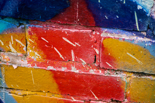 Graffiti - Wolverhampton 2026 - a section of a work has been splattered by grime when another was painted nearby. bright red, yellow, orange and blues