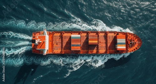 Aerial View of Orange Cargo Ship Sailing Through Deep Blue Ocean Water