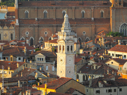 Aerial view of historic Venice architecture with prominent church bell tower among terracotta rooftops