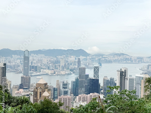 Photography Panoramic view of Hong Kong skyline with skyscrapers and green hillsides on display