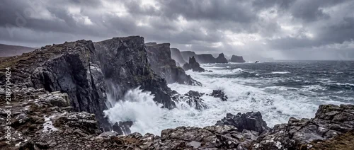 Panel kuchenny z motywem Waves crash against rocky cliffs on a stormy day at the coast Generative AI