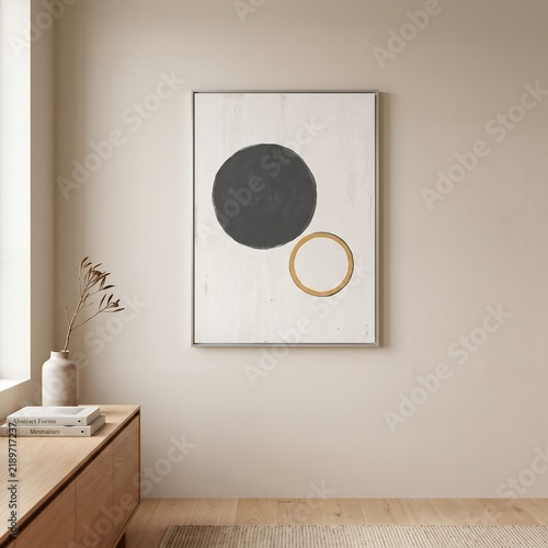 Minimalist geometric artwork with black and gold circles in a warm neutral interior