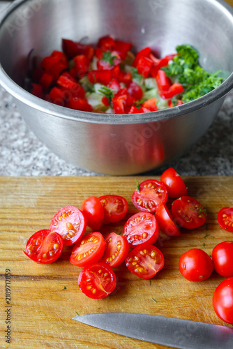 Fotografie Fresh cherry tomatoes chopped on wooden cooking board