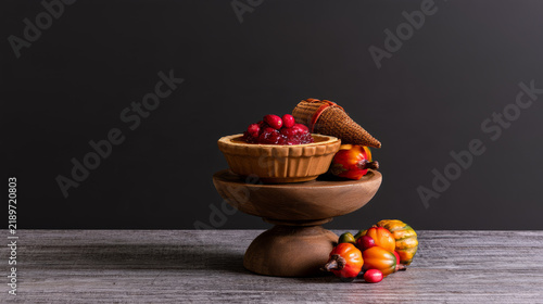 Pumpkin pie with cranberry sauce and miniature cornucopia on wooden stand, Thanksgiving Day dessert