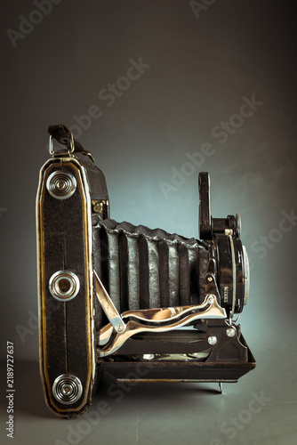 Obraz na płótnie Vintage folding camera with leather bellows on a dark low key background