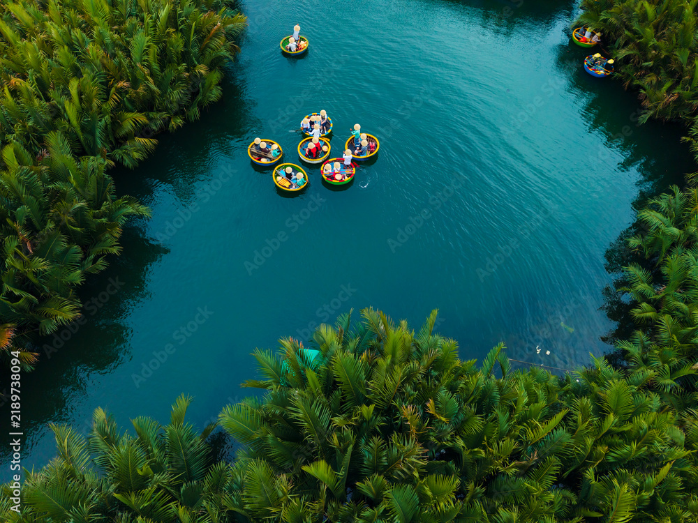 Obraz premium Aerial view of coconut bamboo boats tour in lush greenery of hoi an's waterways, danang, vietnam
