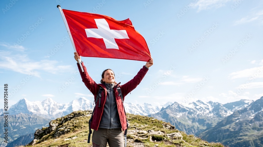 Obraz premium Joyful Woman Hiker Holding Swiss Flag On Mountain Peak