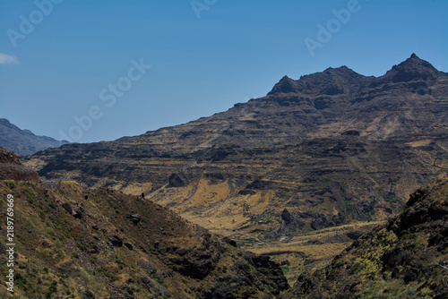 Wide-angle view showing the expansive geological formations, arid valleys, and sharp mountain summits of Gran Canaria.