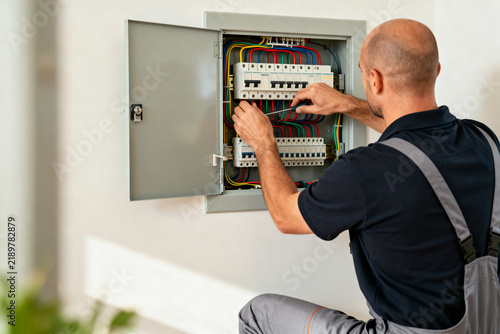 Électricien intervenant sur un tableau électrique dans une maison, dépannage électricité