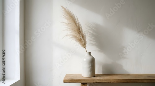 Minimalist interior with dried pampas grass in ceramic vase and warm sunlight