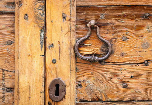 Obraz na płótnie Old wooden door with metal knocker and keyhole in Cremona, Italy