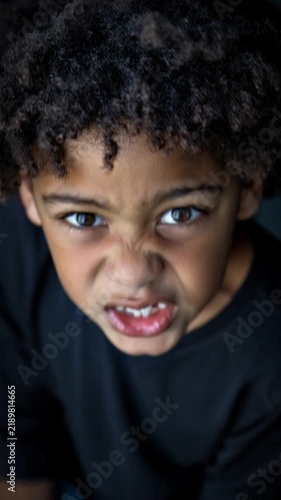 A young boy with curly hair displays intense emotions and varying expressions showcasing anger and frustration captured in a series of dynamic stills from a video.
