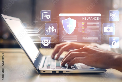 Hands typing on a laptop with graphics related to insurance and healthcare, representing digital technology in medical services and online insurance management. Bitwise.