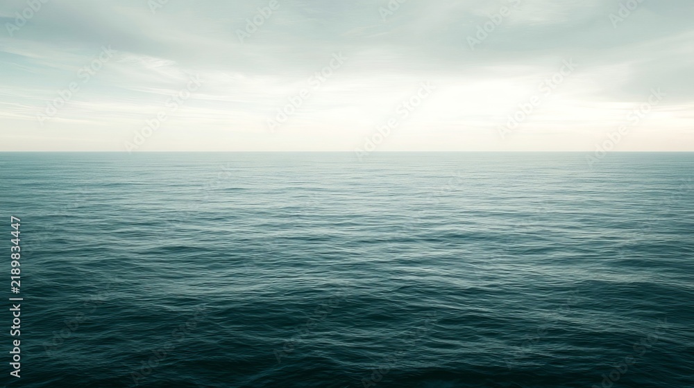 Fototapeta premium Ocean surface meets deep blue sea with cloudy sky overhead.