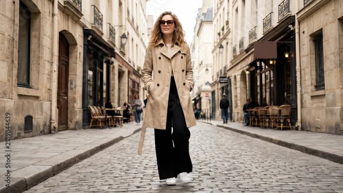 Stylish Woman in Trench Coat Walking Down European City Street