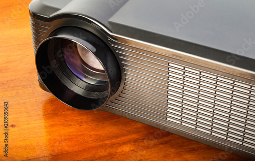 Photo of a table led projector device on wooden table surface.