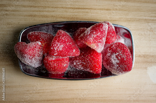 Картината върху платно frozen strawberries resting on a metallic serving tray