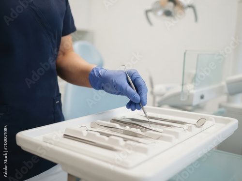 Dentist holding dental tool in clinic, professional oral healthcare and examination procedure