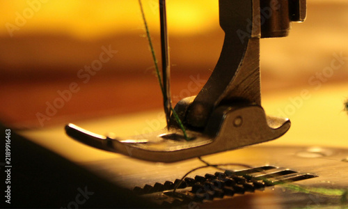 Fotografie Close up view of a sewing machine presser foot with threaded needle ready for fa