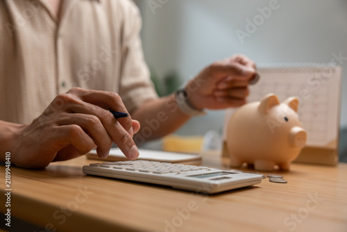 Personal finance planning at home with calculator, savings jar, calendar, and pen