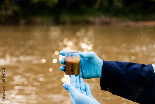 Картината върху платно Environmental technician collecting river sediment sample for contaminant and heavy metal analysis