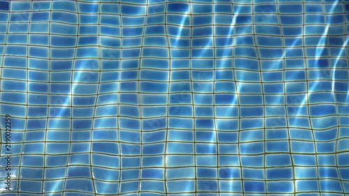 abstract crystal clear to clean rippled water and motion wave in blue swimming pool with sunlight by top view for swim travel and vacation exercise in summer and refreshing and sport background