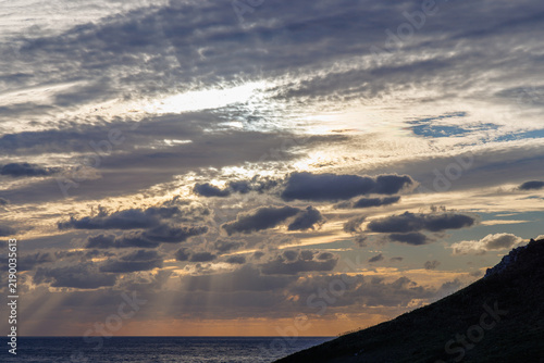 Tapety artystyczne 雲間から海へ光が降り注ぐ夕暮れの海岸風景