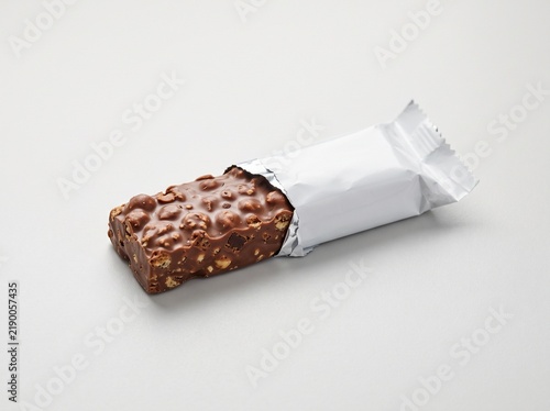 Indulgent nutty chocolate bar, partially unwrapped, showcasing a delightful and satisfying snack experience