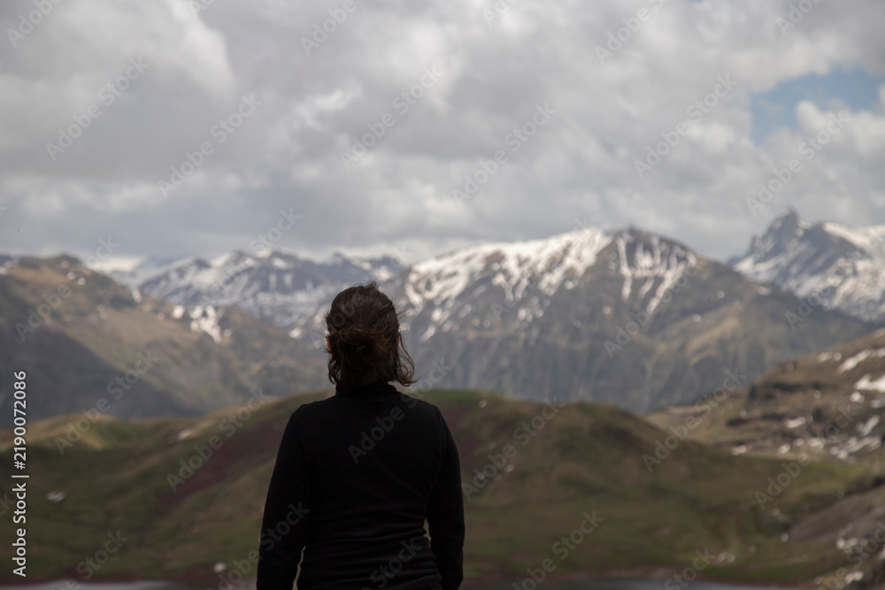 Fototapeta premium Woman observing snowy mountains landscape during outdoor adventure