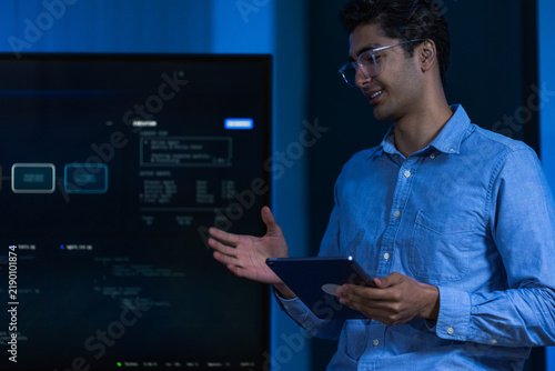 Foto A young male analyst with dark curly hair and clear framed glasses in a light bl