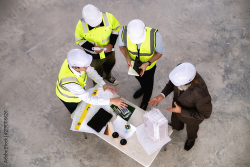 Engineering management team are evaluating construction area to install solar power systems for future green building in city. Concepts of sustainable real estate developers, high angle top view.