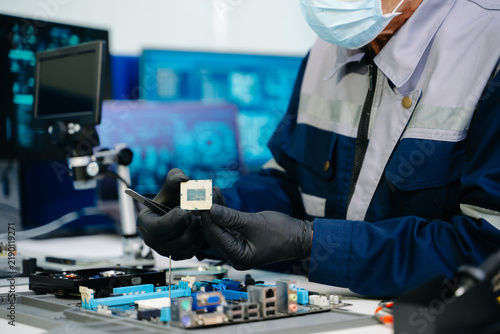 The technician is putting the CPU on the socket of the computer motherboard. electronic engineering electronic repair, electronics measuring