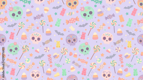 Seamless pattern featuring colorful sugar skulls and assorted halloween candies on a light purple background with bats scattered against soft pastel purple backdrop