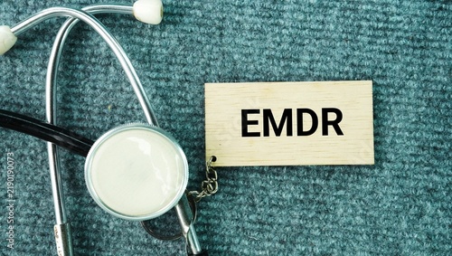 Stethoscope and paper with words Eye movement desensitization and reprocessing EMDR is a talking therapy that helps people heal from the symptoms and emotional distress of disturbing life experiences 