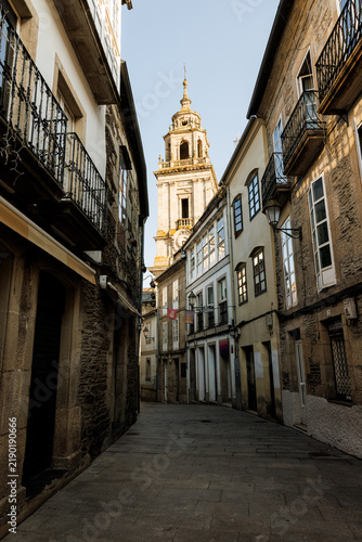 Bild auf Leinwand Narrow Cobblestone Street Leading to Cathedral Bell Tower, Lugo, Spain