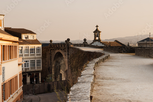 Bild auf Leinwand Historic Stone Archway and Bell Tower at Sunset, Lugo, Spain
