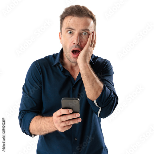Obraz na plátne Stunned casual man holding smartphone