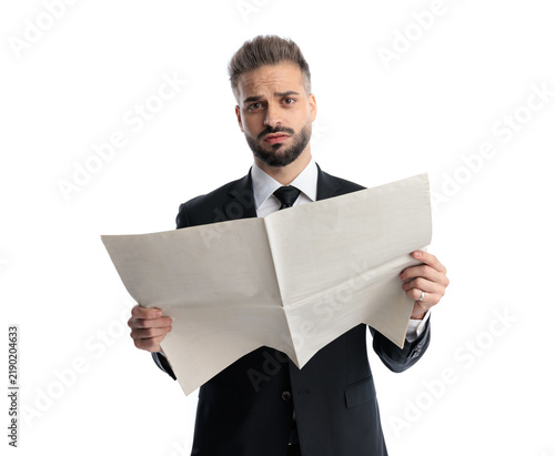 Obraz na płótnie Shocked man holding newspaper and looking forward