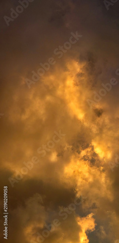 Golden storm clouds glowing at sunset