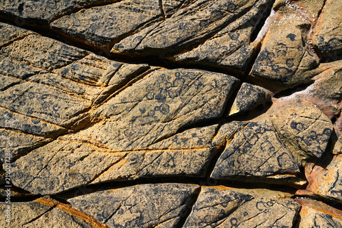Quadro su tela A stone granite rock furrow formation on the Atlantic coast, with grooves and crevices carved out by the waves and seawater, weathered and eroded