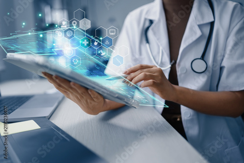 Doctor using a digital tablet with futuristic medical interface and data network in a modern hospital.