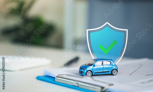 Fotografie Car insurance protection with miniature vehicle and shield on policy documents representing auto coverage accident risk management financial security claims and reliable insurance service