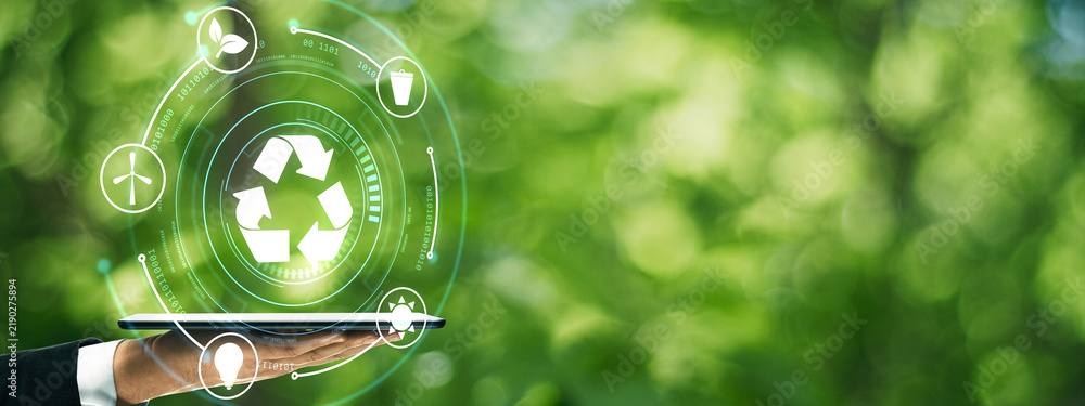 Obraz premium Sustainable recycling technology concept with laptop, clean green nature background, circular economy, eco innovation and environmental responsibility.