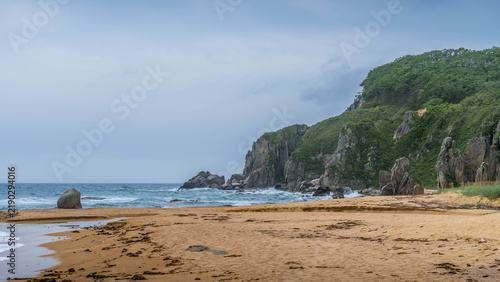 Bild auf Leinwand Beautiful sandy beach on the Sea of Japan in Primorsky Krai, Russia, with warm yellow sand, clear azure water, gentle waves, and a peaceful coastal landscape