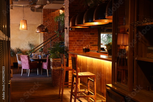 Quadro su tela Intimate dining area with soft lighting and lush plant accents