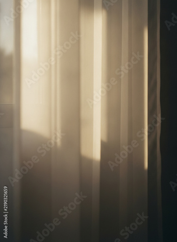 Abstract vertical light stripes and shadows on a wall, soft blurred beige background, minimalist contemporary design, warm tones texture