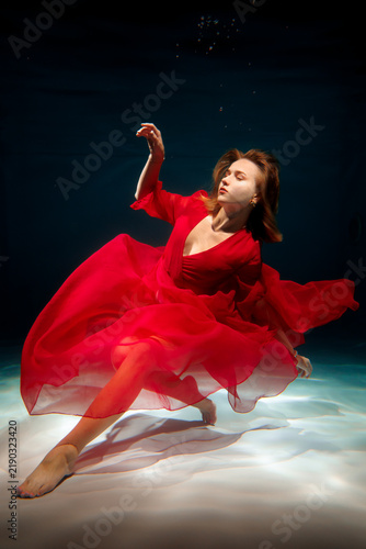 Foto Romantic aquatic woman dressed in silklike red gown reaching outward