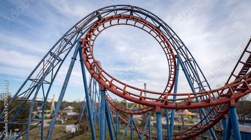Roller coaster with inversion in amusement park against blue sky  