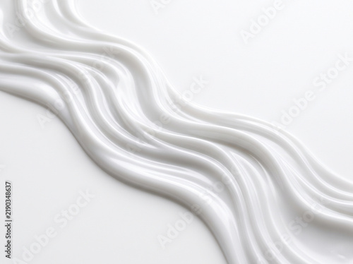 Smooth white cosmetic cream texture with flowing wave pattern on clean background